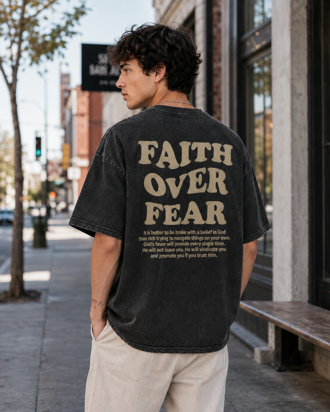 Vintage-style washed white T-shirt featuring the inspirational Christian slogan "Faith Over Fear" in a retro wavy font; a unisex, loose-fitting, distressed-look short-sleeve streetwear top.