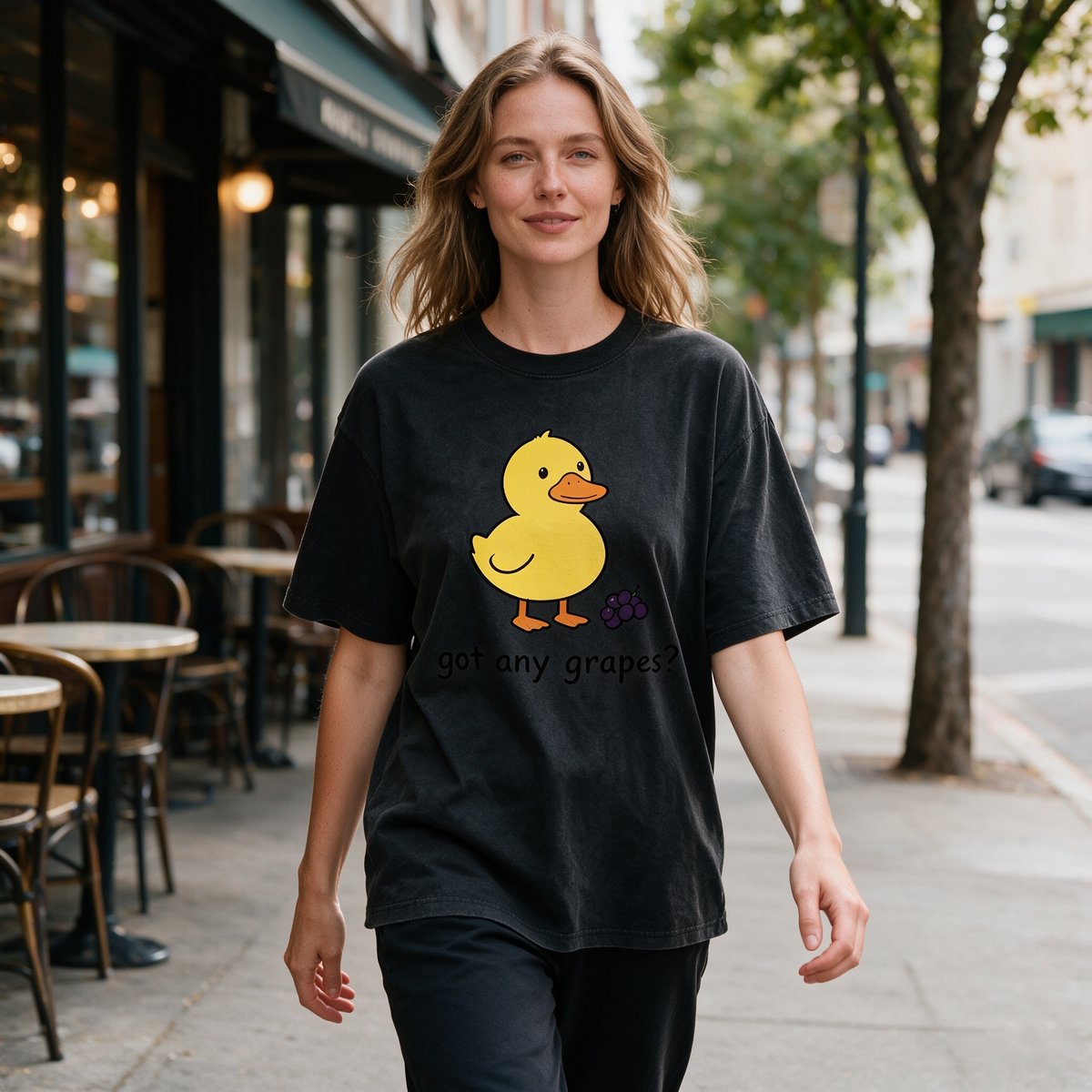 Vintage-style washed cotton T-shirt for women; features a cute graphic of a little yellow duck with grapes and playful English text; designed with a relaxed, drop-shoulder fit and short sleeves.