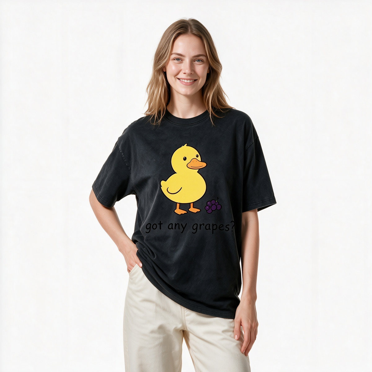 Vintage-style washed cotton T-shirt for women; features a cute graphic of a little yellow duck with grapes and playful English text; designed with a relaxed, drop-shoulder fit and short sleeves.
